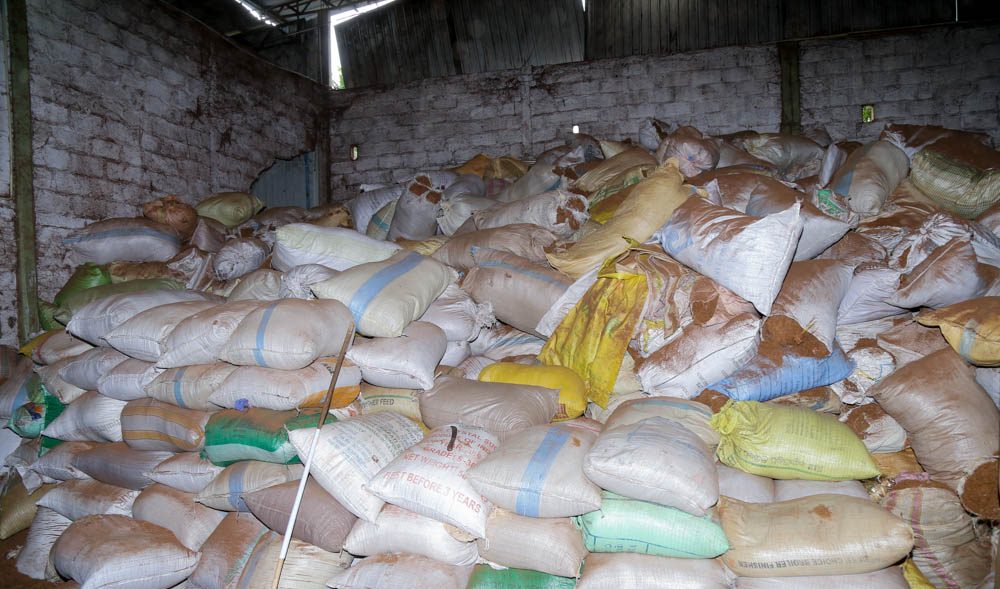 Sacks of raw coir husk stacked to the roof of a store